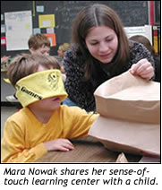 Mara Nowak shares her sense-of-touch learning center with a child.