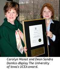 Carolyn Wanat and Dean Sandra Damico display The University of Iowa's UCEA award.